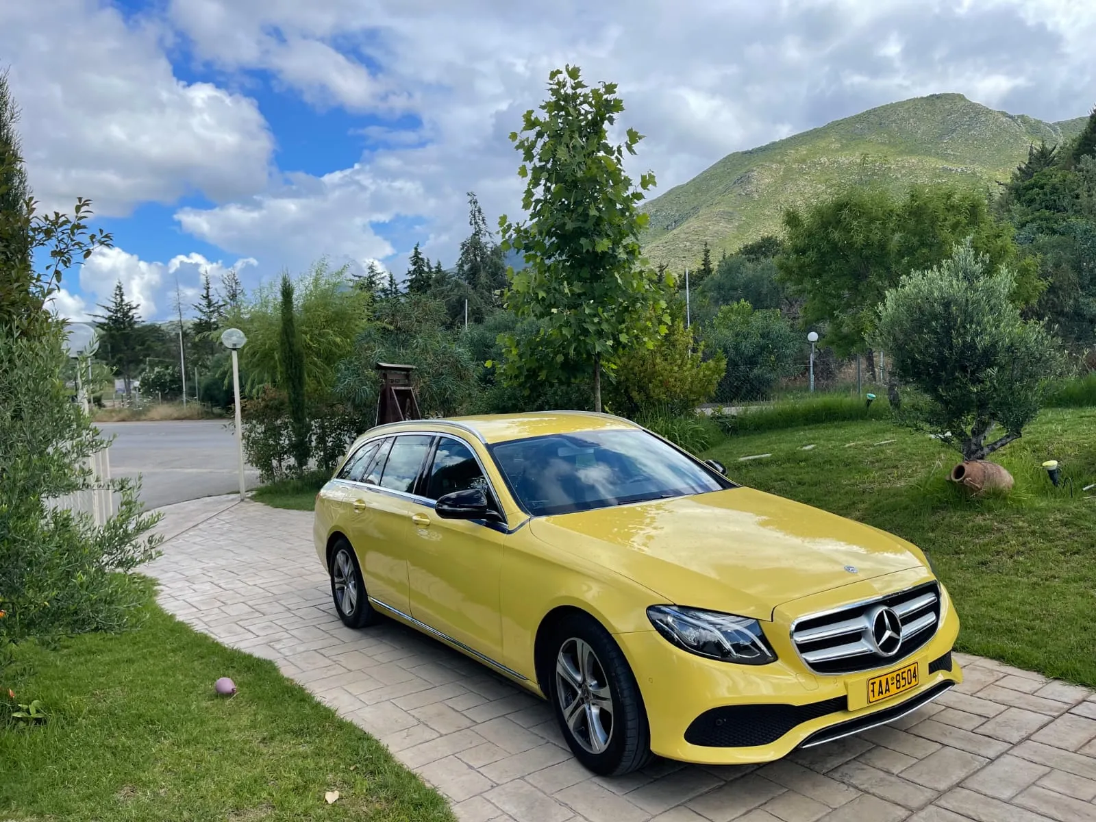 George's yellow Mercedes station wagon taxi with Greek mountains